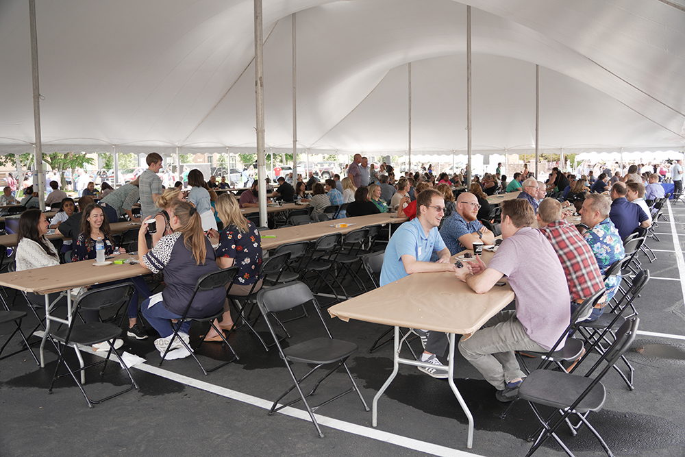 Western National employees enjoying the company picnic under a tent outside.