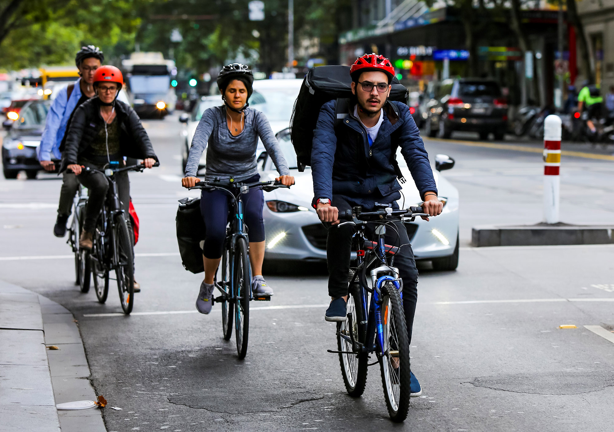 Bicyclists and vehicles on a busy city street.