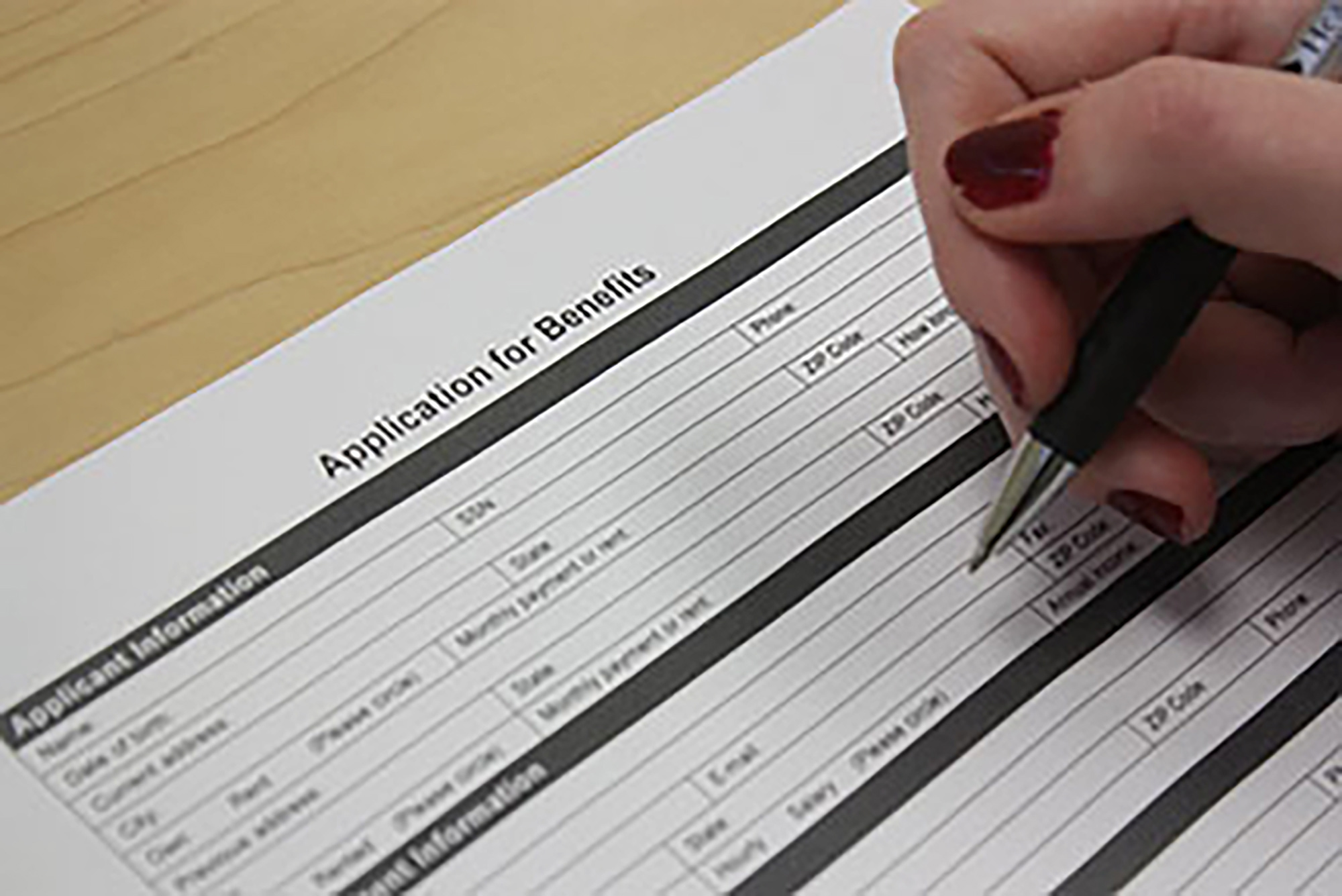 Close-up of a person filling out a benefits application.