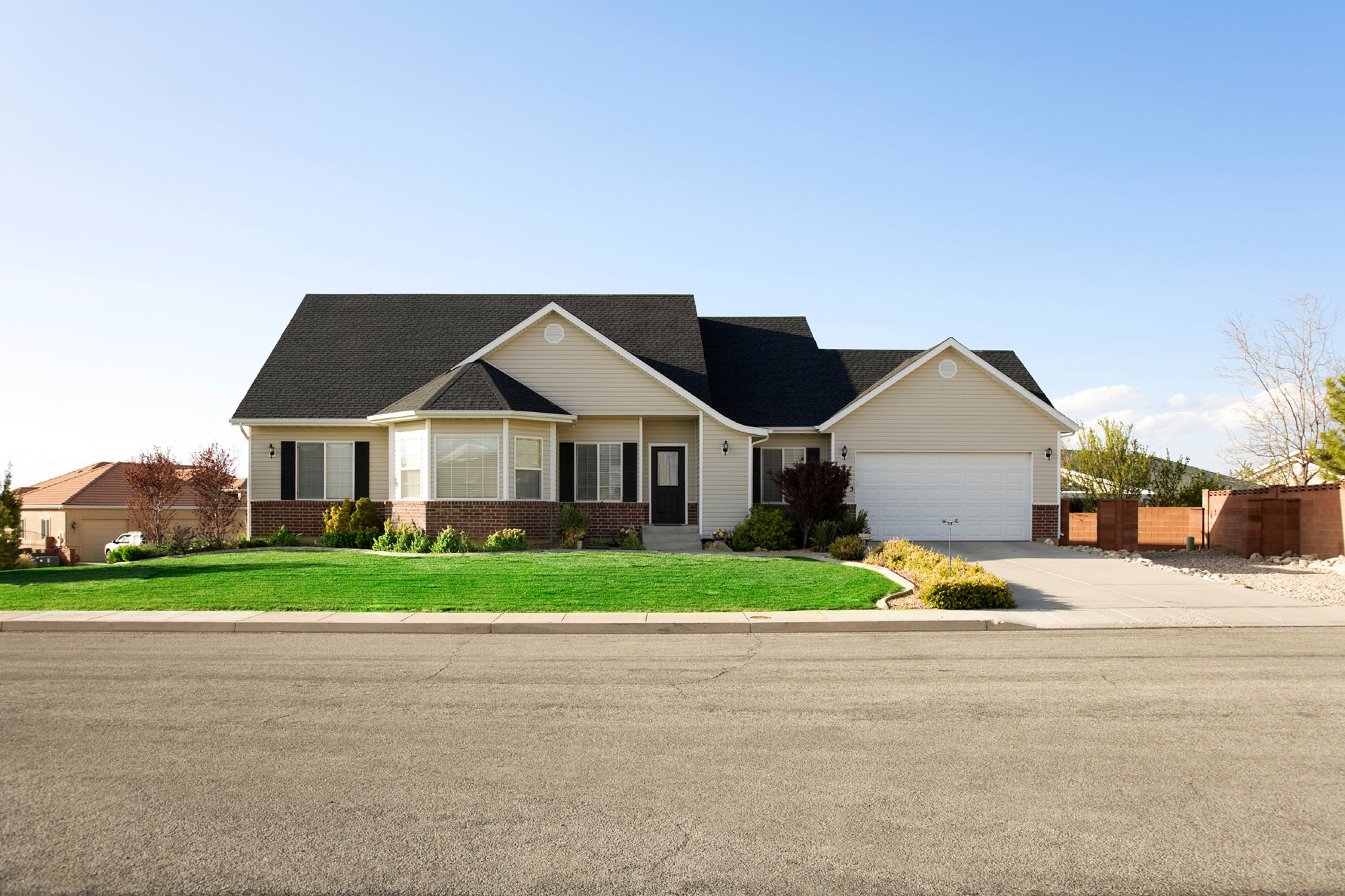 Surburban home with bay window and two car garage.