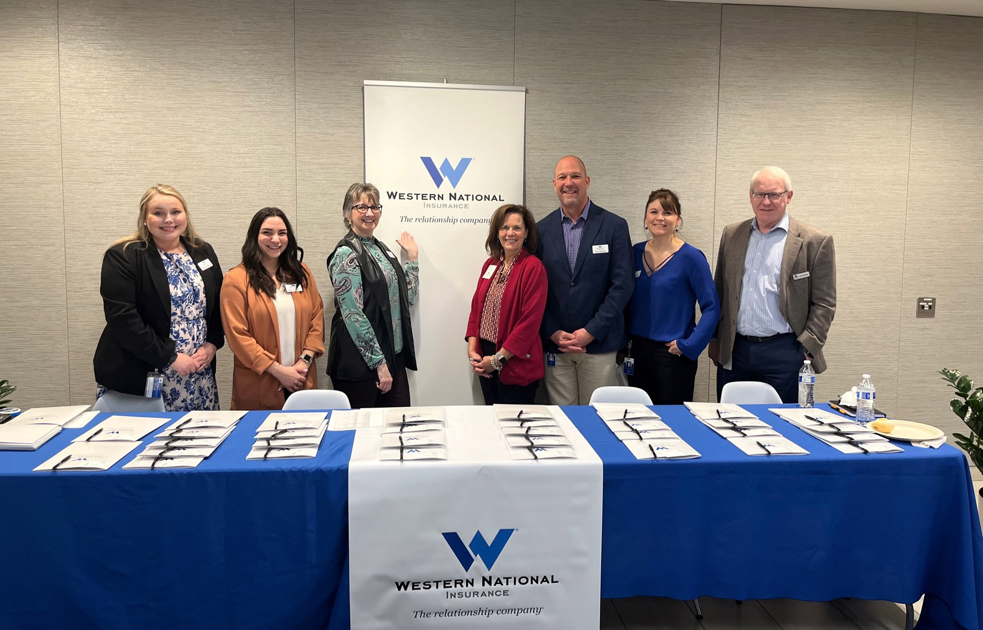 A group on employees smiling for the camera at a Trainee Open House event