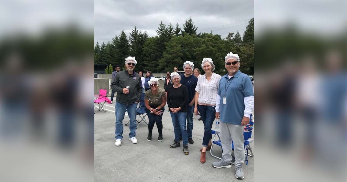 Candid shot of a group of Western National employees hanging out together and playing games on the rooftop deck of Western National's Seattle office.