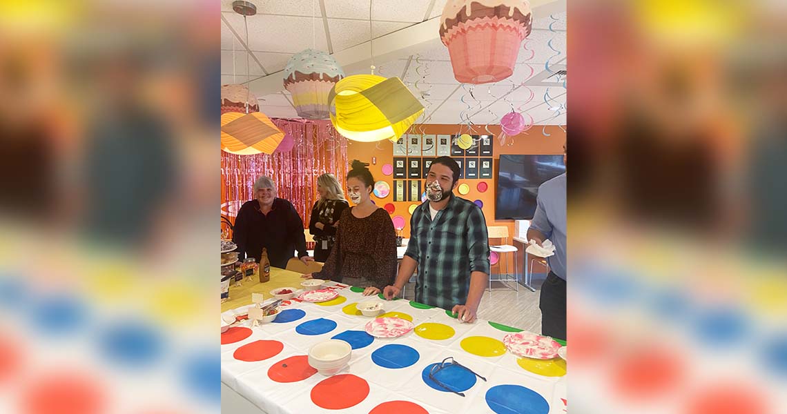 Candid shot of Western National emplpoyees playing games in the lunchroom at Western National's Seattle office with decorations all around the room.