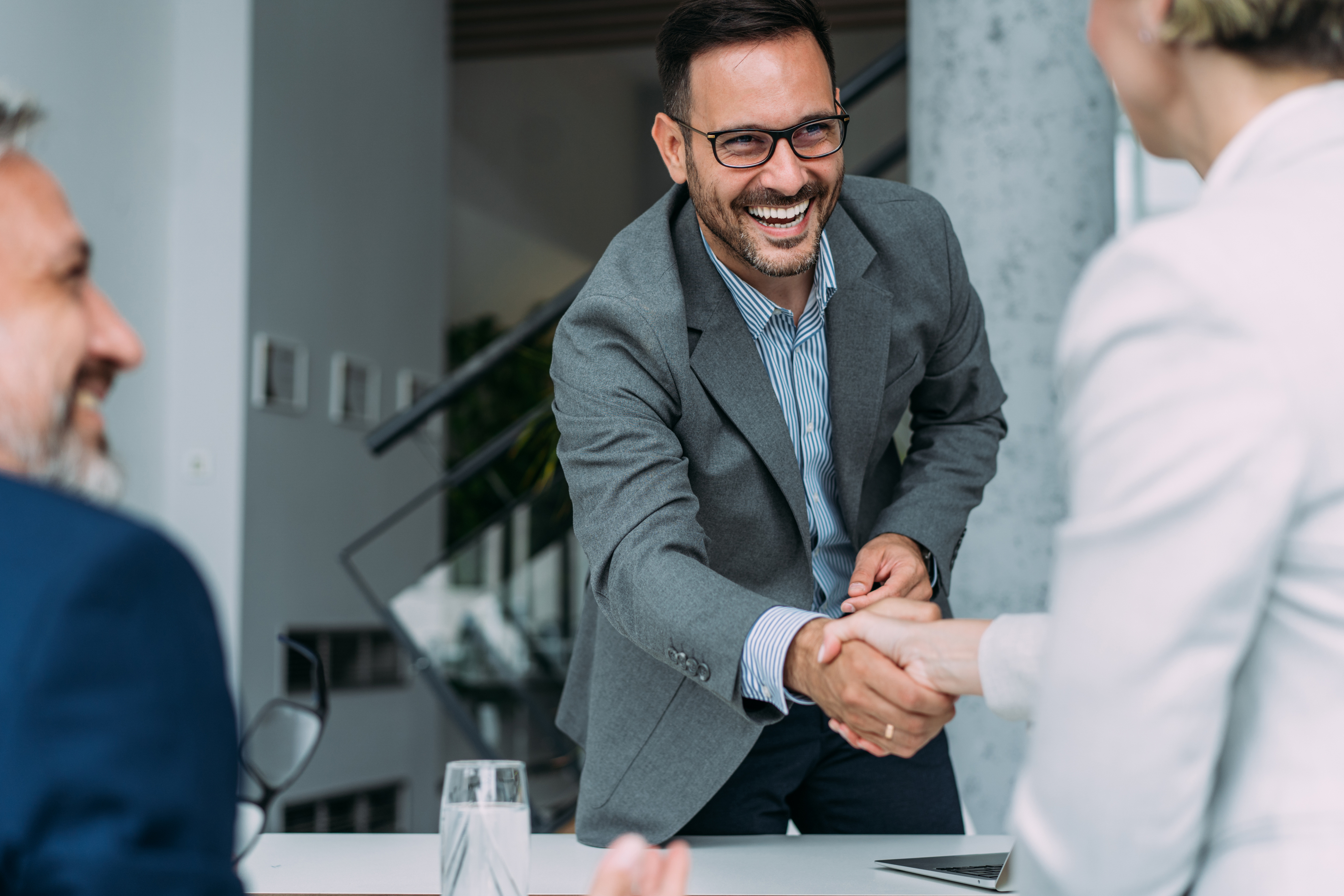 Photo of a group of people meeting and shaking hands.