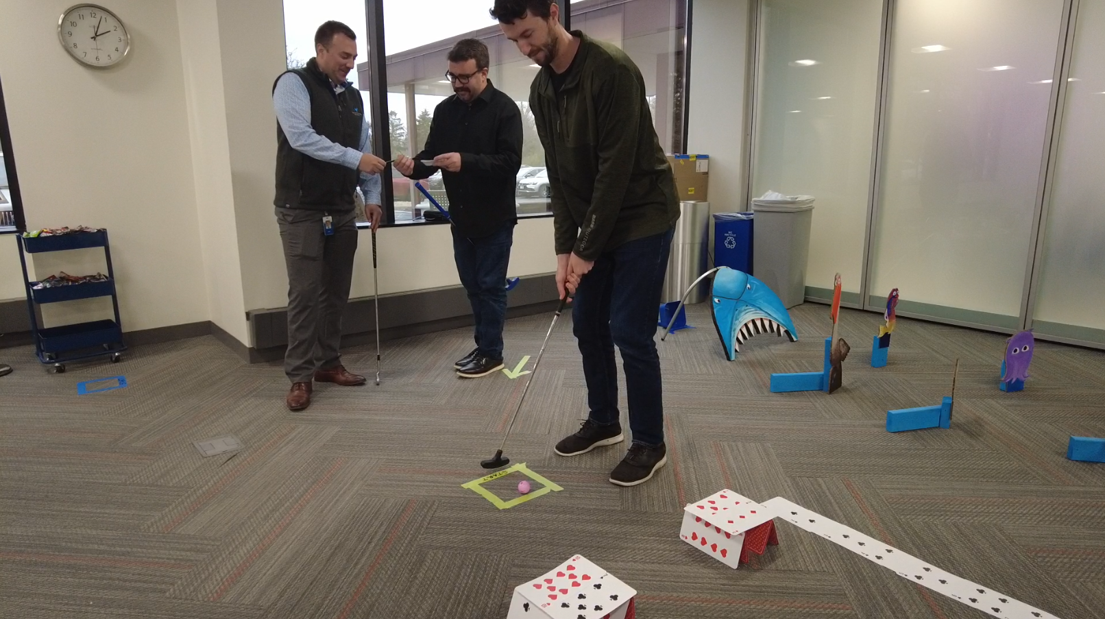 Three Western National employees playing mini golf.