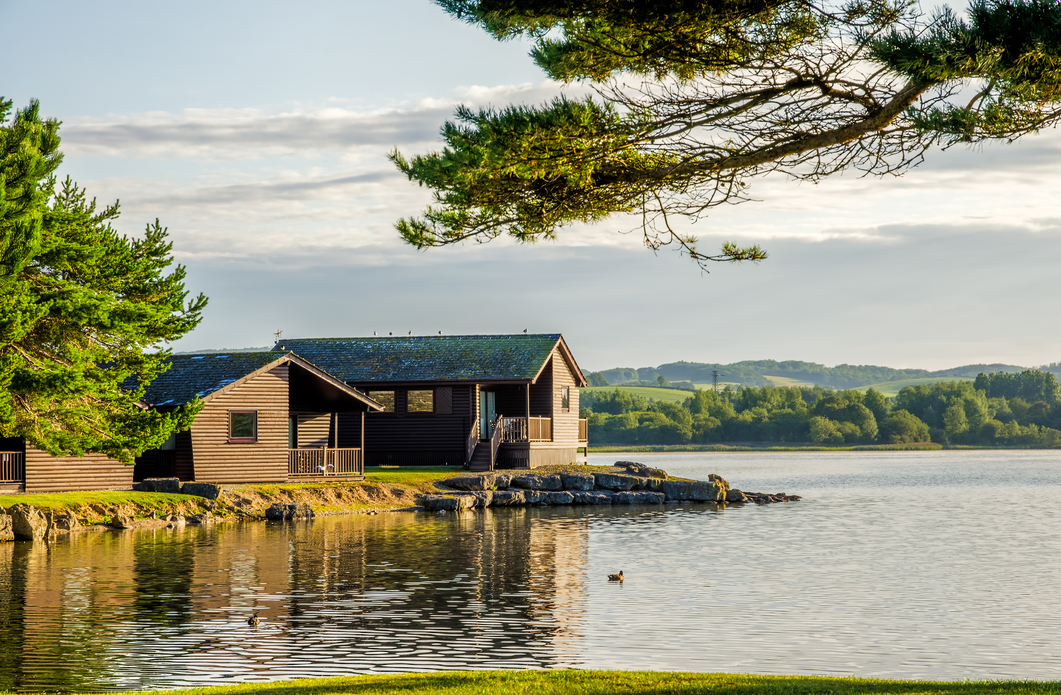 Home overlooking a lake with trees near the background.